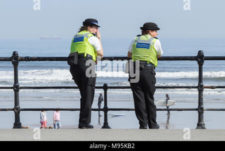 Les agents de police féminins soutien communautaire donnant sur plage sur une journée ensoleillée Banque D'Images