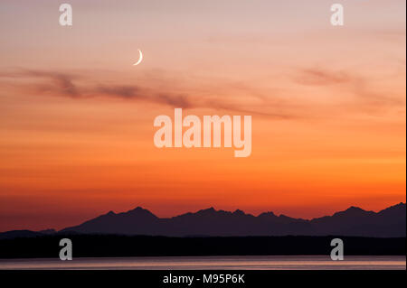 Magnifique coucher de soleil sur les montagnes Olympiques et Puget Sound avec croissant de lune. Banque D'Images