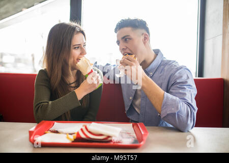 Heureux couple eating fast food burger et döner dans fast food cafe Banque D'Images