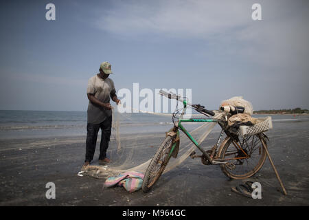 Momodou, un pêcheur local, tire dans ses prises de rouget dont il espère vendre aux collectivités locales de restaurants dans la ville touristique de Kotu, la Gambie. Banque D'Images