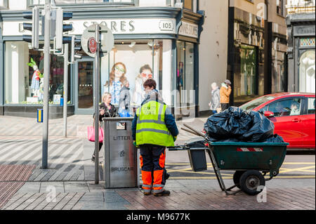 Nettoyeur de rue et shoppers sur St Patrick's Street, Cork, Irlande Banque D'Images