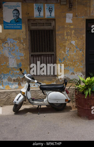 Un vieux cyclomoteur Raja garé en face d'un vieux bâtiment à Stone Town, Zanzibar Banque D'Images