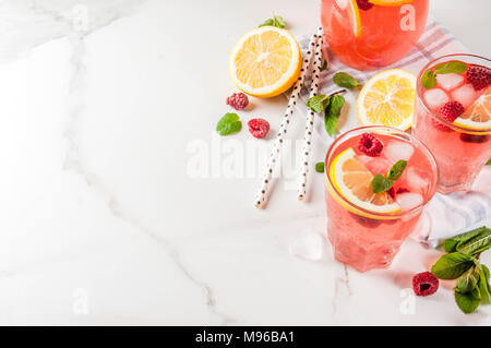 Des boissons rafraîchissantes de l'été, fruits et baies mojito framboise ou la limonade à la menthe fraîche, de framboises surgelées, tranches de citron, glace, sur une lumière backgroun Banque D'Images