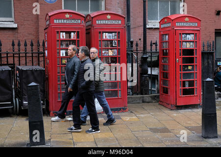 Trois touristes devant Londres cabines téléphoniques. Banque D'Images