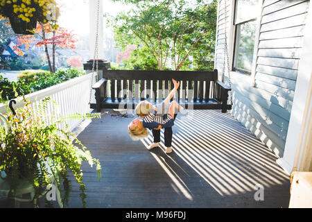 Enfants hugging on porch Banque D'Images