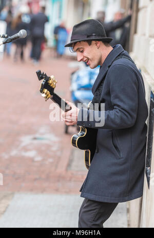 Portrait d'un musicien de la rue de sexe masculin le divertissement du public comme le musicien ambulant joue de la guitare à Brighton, East Sussex, Angleterre, Royaume-Uni. Banque D'Images