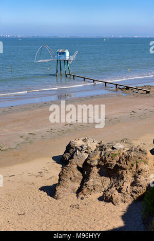 Carrelets de pêche de Pornic à marée basse et de la ville de Saint Nazaire en arrière-plan dans les pays de la Loire dans l'ouest de la France Banque D'Images