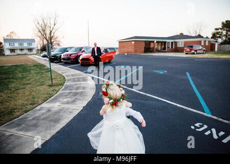 Fille en robe blanche en parking avec guirlande de fleurs Banque D'Images