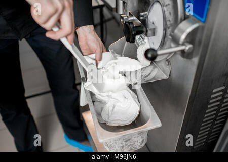 Chef de la crème glacée à partir de blanc la sorbetière machine dans la fabrication de petits Banque D'Images