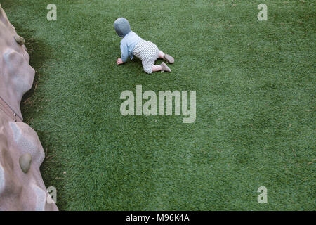 Baby crawling on grass Banque D'Images