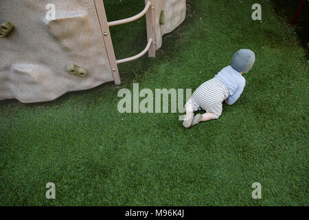 Baby crawling on grass Banque D'Images