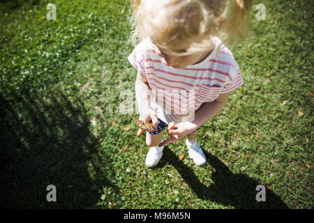 Girl holding butterfly Banque D'Images