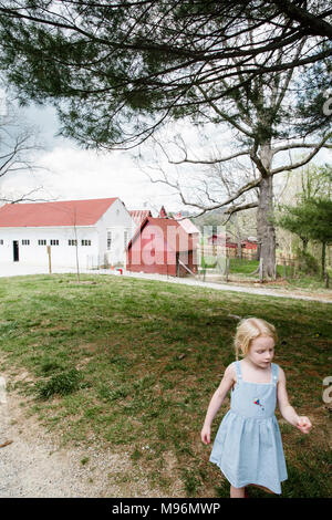 Girl standing outside of barn Banque D'Images