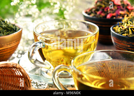 La composition avec tasse de thé et des bols de feuilles de thé. Banque D'Images