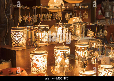 Les chandeliers en verre avec décoration de carrousel métalliques émettent la lumière magique dans la nuit sur le marché de Noël pendant l'avent. Banque D'Images