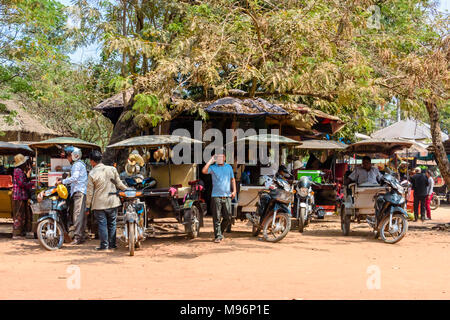 Chauffeurs attendent avec leurs garé tuk-tuks (motocyclettes avec une remorque utilisée comme taxi) au Cambodge. Banque D'Images