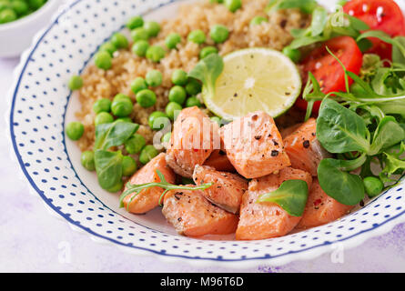 Dîner sain. Tranches de saumon grillé, le quinoa, les pois verts, les tomates, les feuilles de laitue et de chaux Banque D'Images