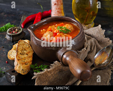 Soupe de tomates épicée avec des boulettes de viande, pâtes et légumes. Dîner sain Banque D'Images