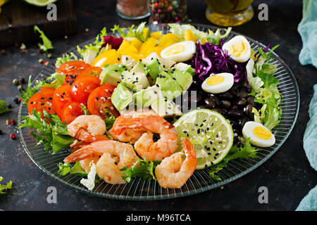 Salade saine plaque. Recette de fruits de mer frais. Crevettes grillées et salade de légumes frais - avocat, tomate, haricots noirs, le chou rouge et le paprika. Des grillades Banque D'Images