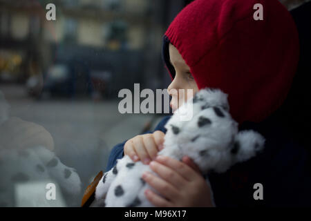 Enfant tenant Soft Toy voyageant en bus, à la fenêtre de Banque D'Images