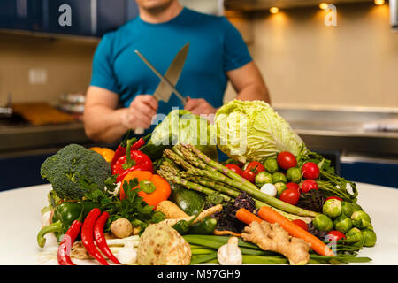 Homme avec une grande variété de légumes, prêts à être cuisinés Banque D'Images