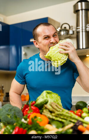 Homme avec une grande variété de légumes, prêts à être cuisinés Banque D'Images