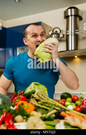 Homme avec une grande variété de légumes, prêts à être cuisinés Banque D'Images
