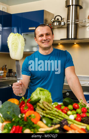 Homme avec une grande variété de légumes, prêts à être cuisinés Banque D'Images
