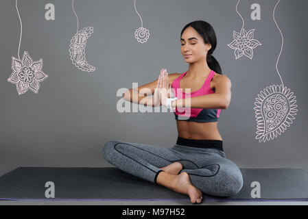 Calme femme assise avec ses yeux fermés et méditant Banque D'Images