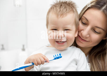 L'enseignement de mère heureuse son fils comment bush les dents dans la salle de bains Banque D'Images