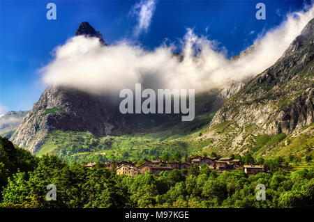 Le village de Chiappera, dans la haute vallée de la Maira à Piedmont, le rock, surmontée d 538, partiellement enrobée depuis les nuages. Banque D'Images