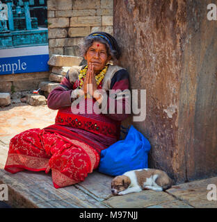 Vieille Femme avec chien mendier au temple de Pashupatinath à Katmandou Népal, Banque D'Images