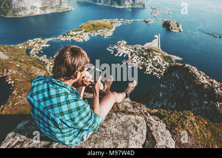 L'homme à l'aide de voyageurs se reposant sur le smartphone haut de mountain Voyager concept de vie en plein air d'aventure vue aérienne falaise de montagne vacances d'été Banque D'Images