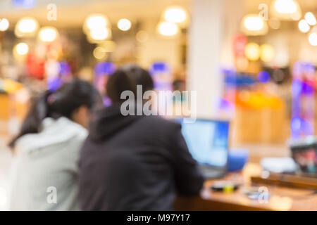 Flou, du flou, de l'image de deux personnes travaillant sur leur ordinateur dans un lieu public bien éclairé, bon pour n'importe quel thème historique Banque D'Images