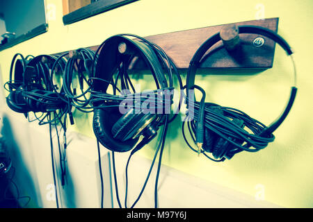 Jeu d'écouteurs accrochés dans un enregistrement studio privé Banque D'Images