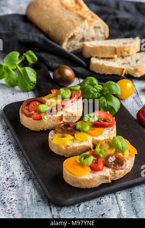 Bruschetta, pain ciabatta avec multi-couleur de tomates au basilic Banque D'Images