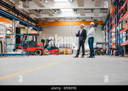 Deux hommes portant des casques en magasin d'usine marbre Banque D'Images