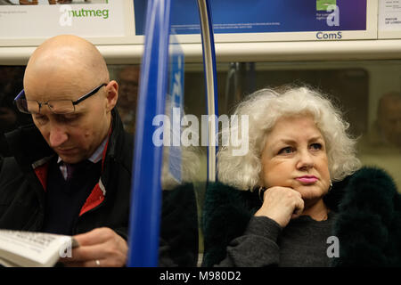 Un homme et une femme à côté de l'autre dans un train. Banque D'Images