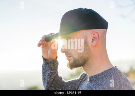 Jeune homme portant une casquette à rétro-éclairage Banque D'Images