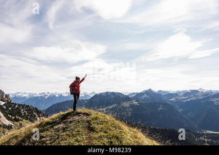 Autriche, Tyrol, young woman cheering mountainscape Banque D'Images