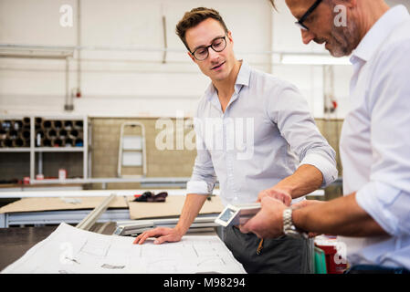 Deux hommes d'en discuter et d'usine de composants plan Banque D'Images