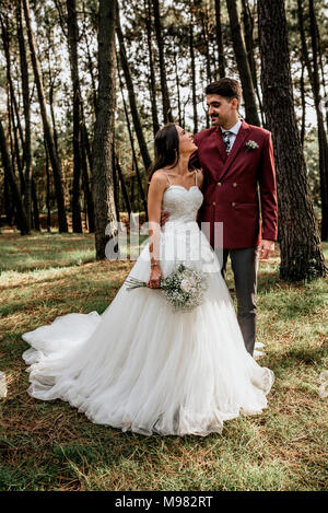 Heureux couple standing in forest Banque D'Images