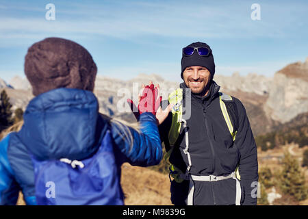 Smiling man and woman hiking dans les montagnes fiving haut Banque D'Images