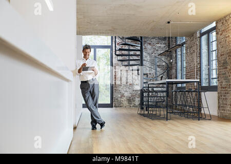 Businessman using tablet in modern office Banque D'Images