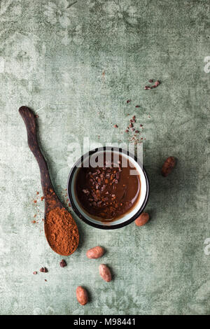 Tasse de chocolat au lait avec le cacao, cacao nibs et les fèves de cacao Banque D'Images