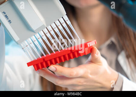 Chercheur en laboratoire microbiologique femme avec pipette multicanaux test ADN va Banque D'Images