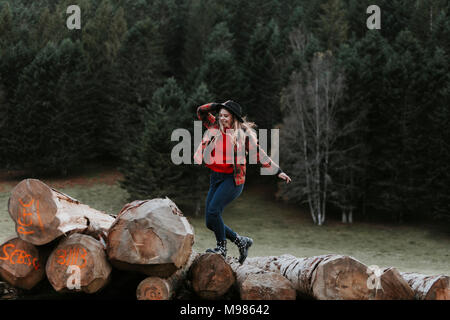 Young woman balancing on logs Banque D'Images