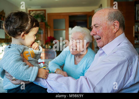 Grands-parents jouer avec bébé girl at home Banque D'Images
