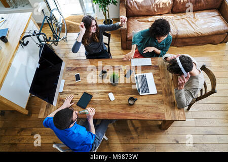 Portrait de collaborateurs à l'écoute de la musique à l'office de table en bois Banque D'Images