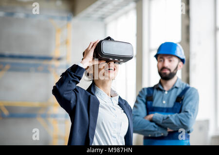 Femme portant des lunettes VR client sur le site de construction Banque D'Images